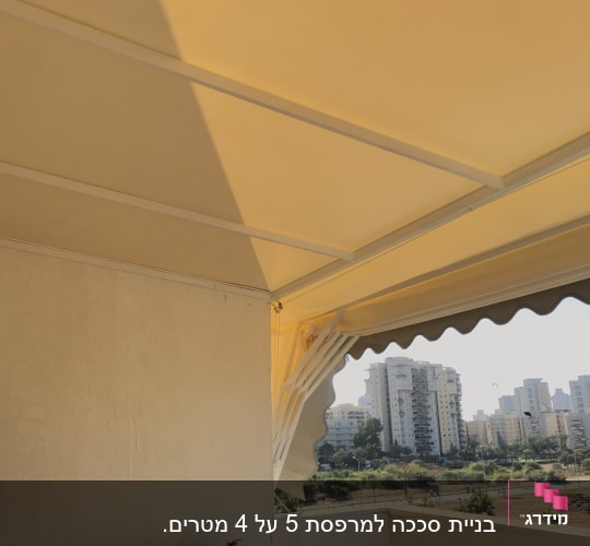 סוכך צהוב עם מסגרת לבנה על מרפסת